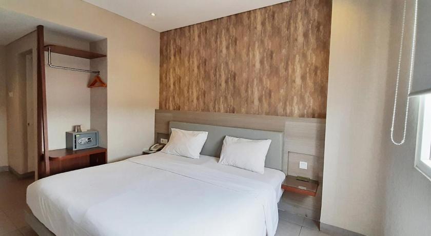 a bedroom with a white bed and white walls, LYNN Hotel Serang in Banten