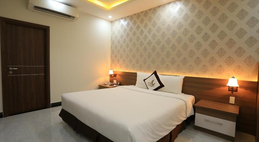a hotel room with a bed and two lamps, Phung Hung Boutique Hotel in Phu Quoc Island