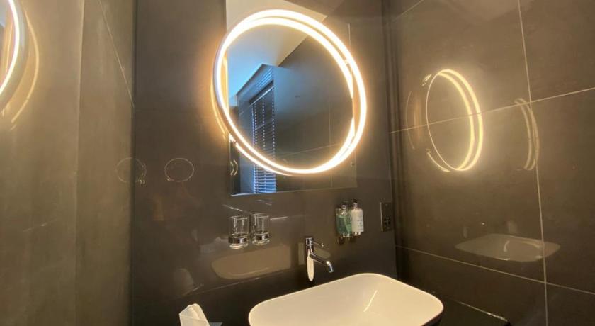 a bathroom with a sink, mirror, and bathtub, The Bold Hotel; BW Signature Collection in Sefton