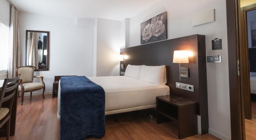 a hotel room with a bed and a desk, Hotel Alda Zaragoza Independencia in Zaragoza