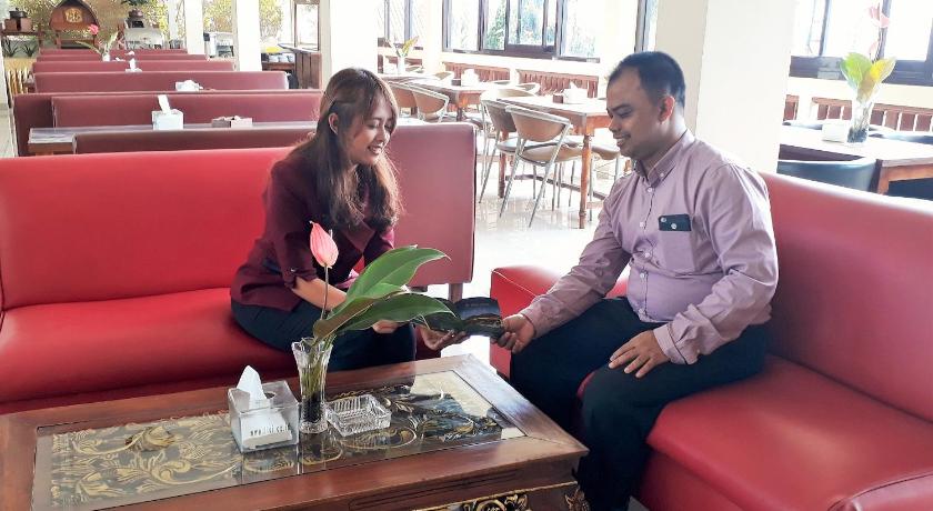 a man and woman sitting at a table in a restaurant, Taman Teratai Hotel in Puncak