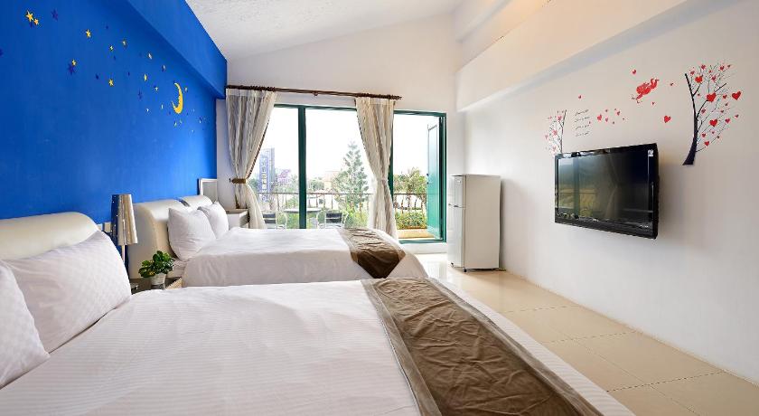 a hotel room with a bed, tv and a window, DaJenShan Style Resort in Kenting