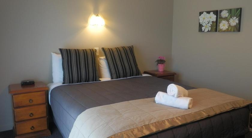 a bedroom with a bed and a dresser, Lake Wanaka Lodge in Wanaka