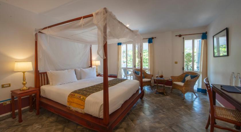 a hotel room with a bed and a canopy, The Belle Rive Boutique Hotel in Luang Prabang