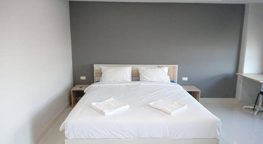 a hotel room with a white bed and white walls, Ploen Ploen Residence in Pathum Thani