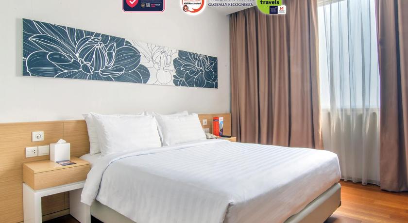 a bedroom with a bed, a desk and a painting on the wall, Swiss-Belinn Airport Jakarta in Jakarta