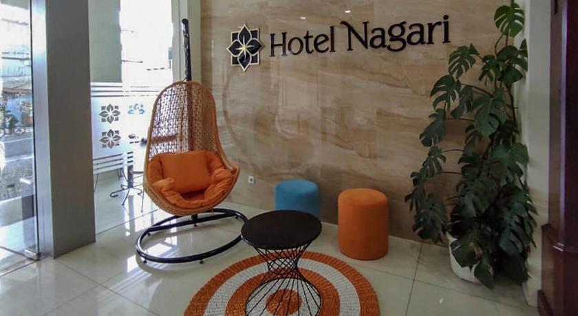 a room with a chair and a clock on the wall, Hotel Nagari in Yogyakarta