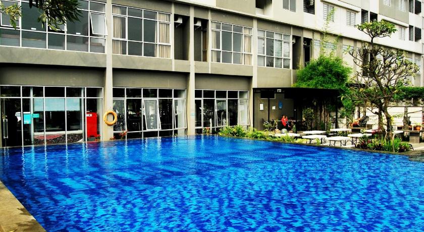 a building with a pool in the middle of it, High Livin Apartment Baros in Bandung