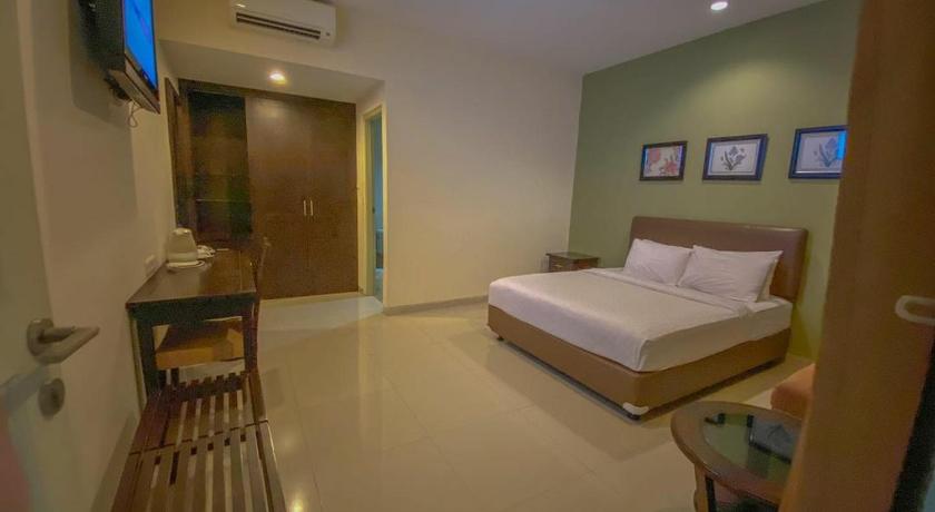 a bedroom with a bed and a dresser, Le Krasak Boutique Hotel in Yogyakarta