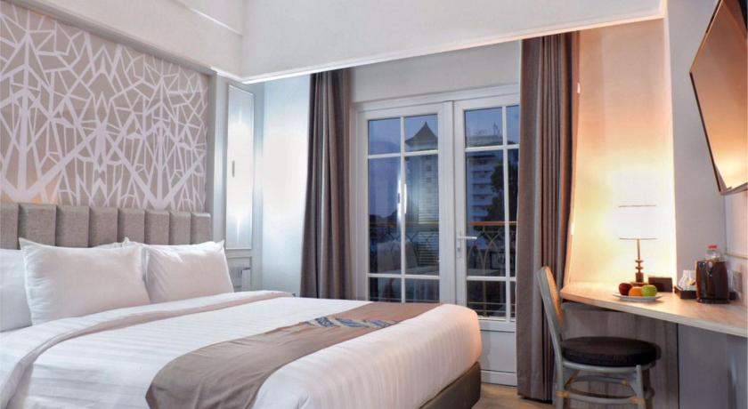 a hotel room with a bed and a lamp, Solia Hotel Yosodipuro Solo in Surakarta
