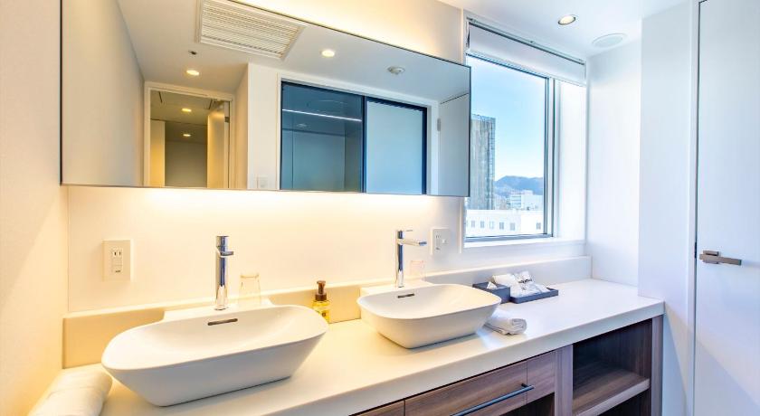 a bathroom with two sinks and a mirror, Tenza Hotel and SKYSPA at Sapporo Central in Sapporo