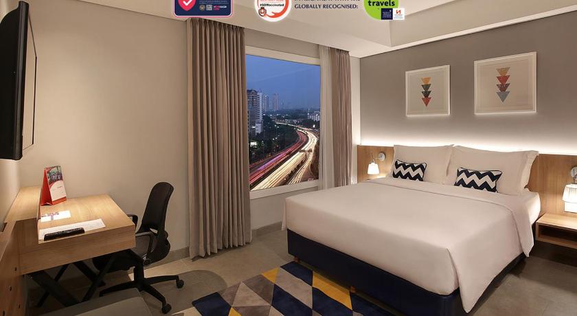 a hotel room with a bed and a desk, Swiss-Belinn Simatupang in Jakarta