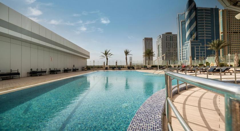a large swimming pool in the middle of a city, Novotel Fujairah Hotel in Fujairah