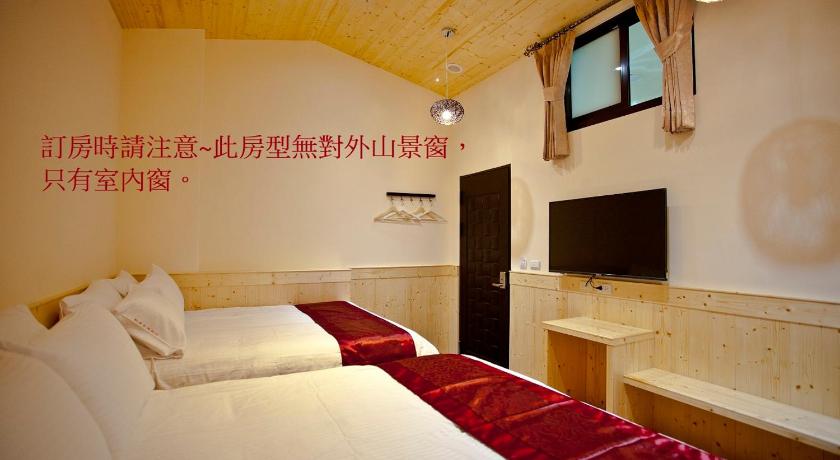 a hotel room with two beds and a television, Sin Ging Hong Resort in Nantou