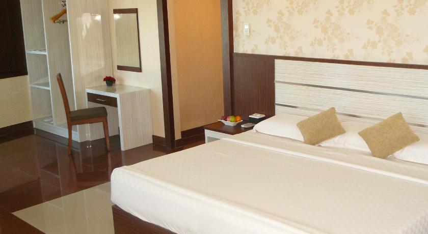 a hotel room with two beds and a television, Hotel Oval in Surabaya