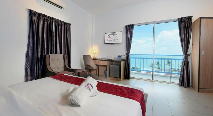 a hotel room with a large bed and a large window, Royal Agate Beach Resort in Langkawi