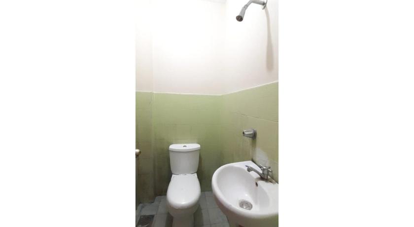 a white toilet sitting next to a sink in a bathroom, OYO 558 Edilberto's Place in Tagum