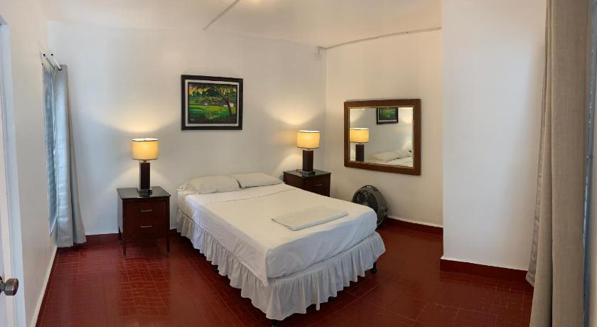 a hotel room with a bed and a desk, Palmira Hostel in Tegucigalpa