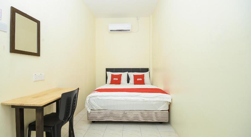 a bedroom with a bed, desk, chair and lamp, OYO 90172 Batu Niah Homestay in Miri