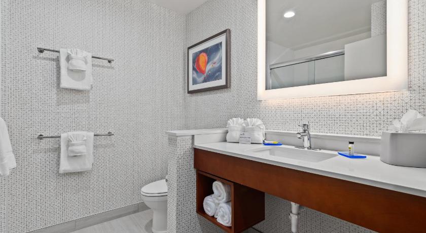 a bathroom with a toilet, sink, and mirror, Holiday Inn Express Orlando - Lake Buena Vista Area in Orlando (FL)