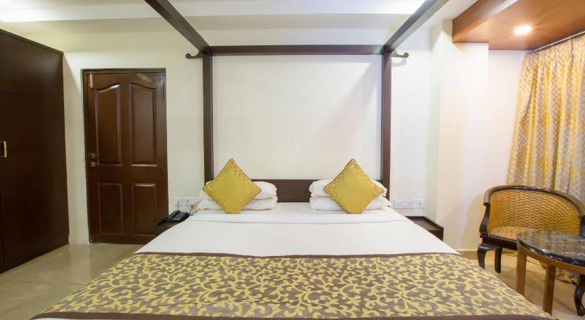 a hotel room with a bed, chair, and nightstand, TSG Emerald View Hotel and SPA in Andaman and Nicobar Islands