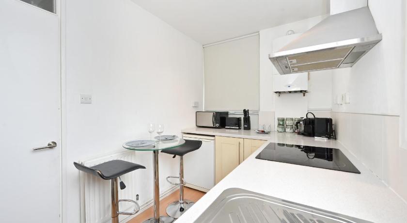 a kitchen with a sink, stove, microwave and refrigerator, Nice Apartment - Great Portland St, Regents Pk, Euston in London