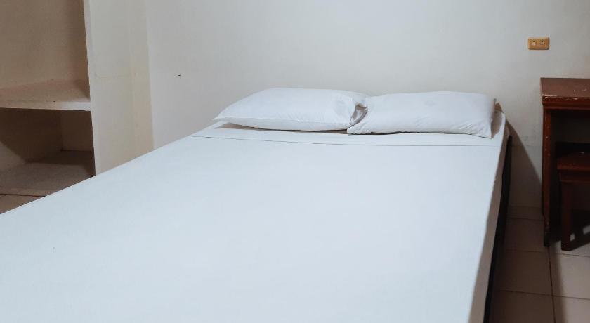 a white bed sitting in a room next to a wall, RedDoorz @ Baldevia Silay in Silay City