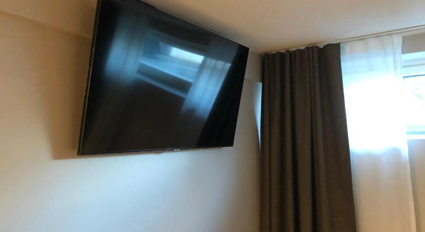 a television mounted on a wall next to a window, HOSTEL TOIVOLA in Kemi