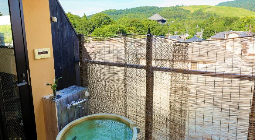 a bathroom with a tub and a toilet, New Wakasa Annex Hotel in Nara
