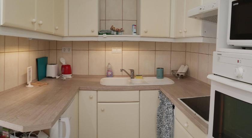 a kitchen with a sink, stove, microwave and dishwasher, A charming little flat just above Szechenyi Square in Pecs