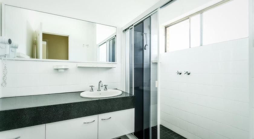 a bathroom with a sink and a mirror, Sandcastles Holiday Apartments in Coffs Harbour