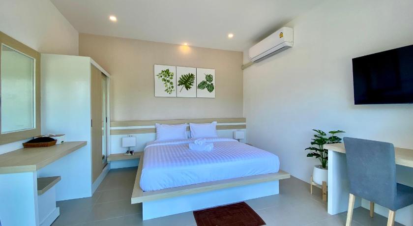 a hotel room with a bed and a table, Pure Laguna Residence by Nice Sea Resort in Koh Phangan