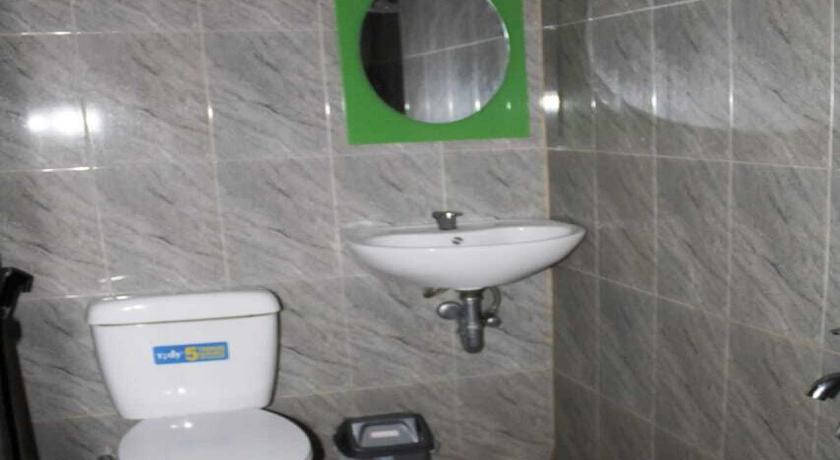 a bathroom with a toilet, sink, and mirror, OYO 2799 Berastagi Backpacker Rooms in Berastagi
