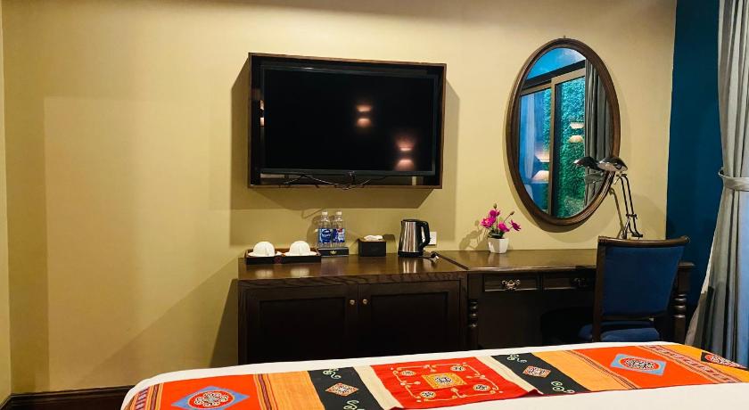 a hotel room with a television and a bed, Nomadtrails boutique hotel in Sapa