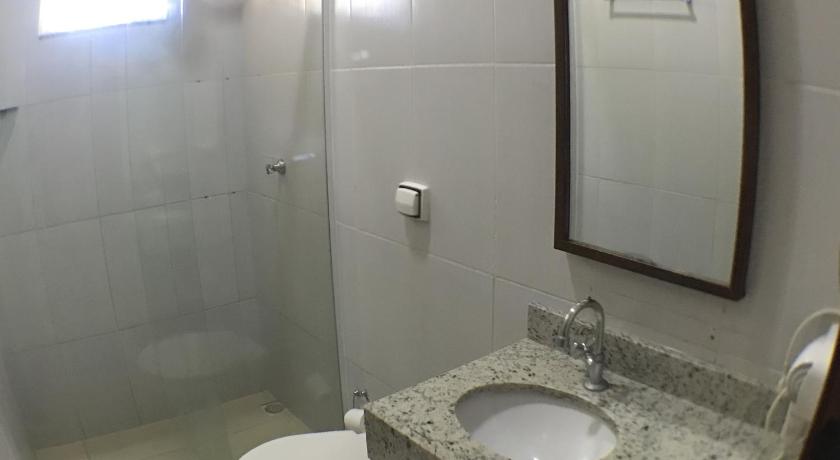 a bathroom with a toilet, sink and mirror, Hotel Pousada Calliandra in Bonito