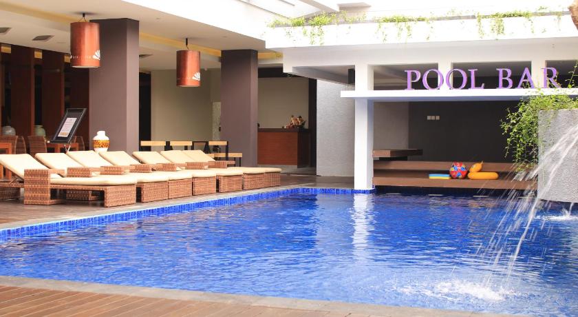 a pool with a pool table and chairs in it, Crystal Lotus Hotel Yogyakarta in Yogyakarta