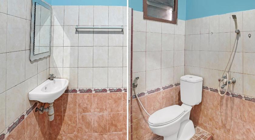 a bathroom with a toilet, sink, and shower, OYO 90487 Wisma Kuta Karang Baru in Lhokseumawe
