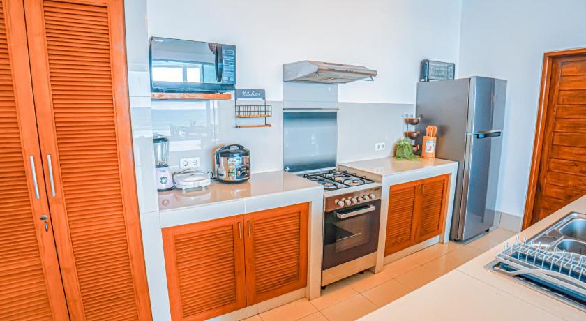 a kitchen with a stove, refrigerator, sink and microwave, Air Sanih Beach Villa in Bali