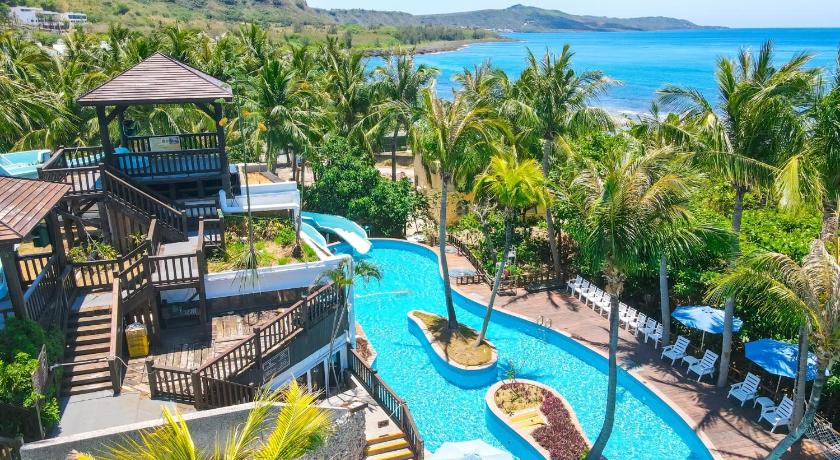 a beach with a pool, chairs, and tables, Yoho Beach Resort in Kenting