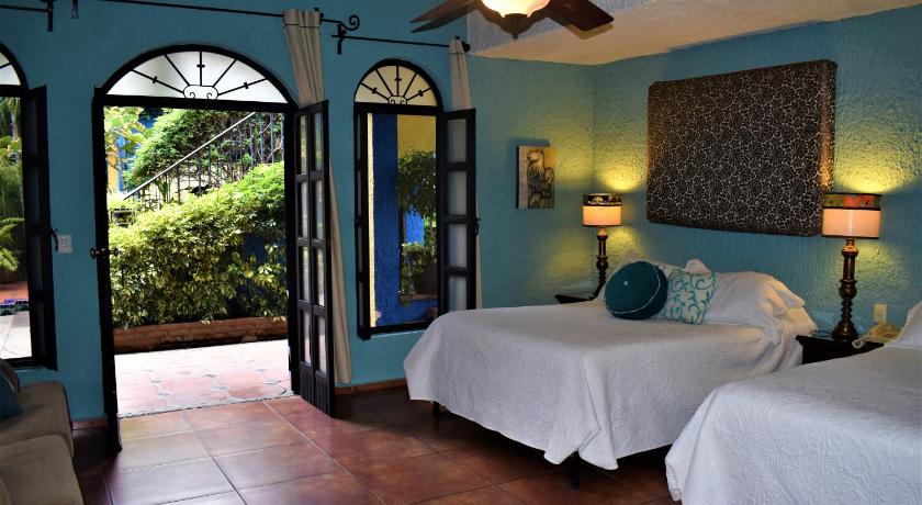 a bedroom with two beds and a large window, La Villa del Ensueno Boutique Hotel in Guadalajara