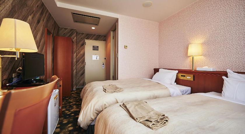 a hotel room with two beds and a television, Annex Royal Hotel in Odate