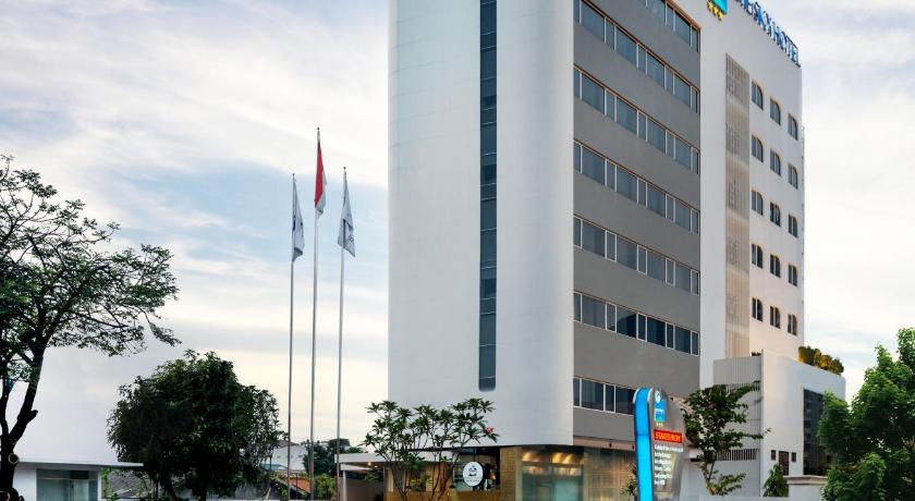 a large building with a large clock on the side of it, Blue Sky Hotel Petamburan in Jakarta