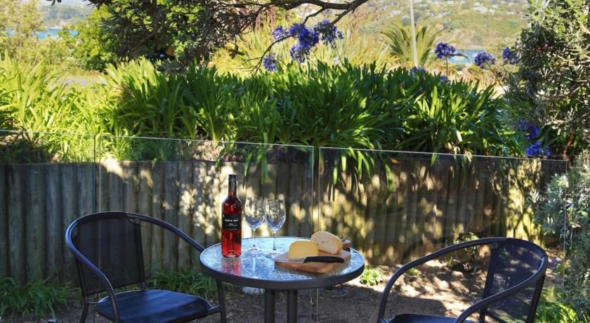 a table with a bottle of wine and a picnic table cloth, Tutiri in Oneroa in Waiheke Island