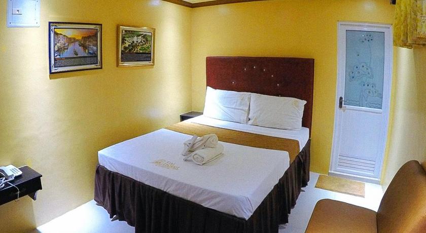 a hotel room with a white bed and white walls, RedDoorz Plus @ Taj Hotel Tuguegarao in Tuguegarao City