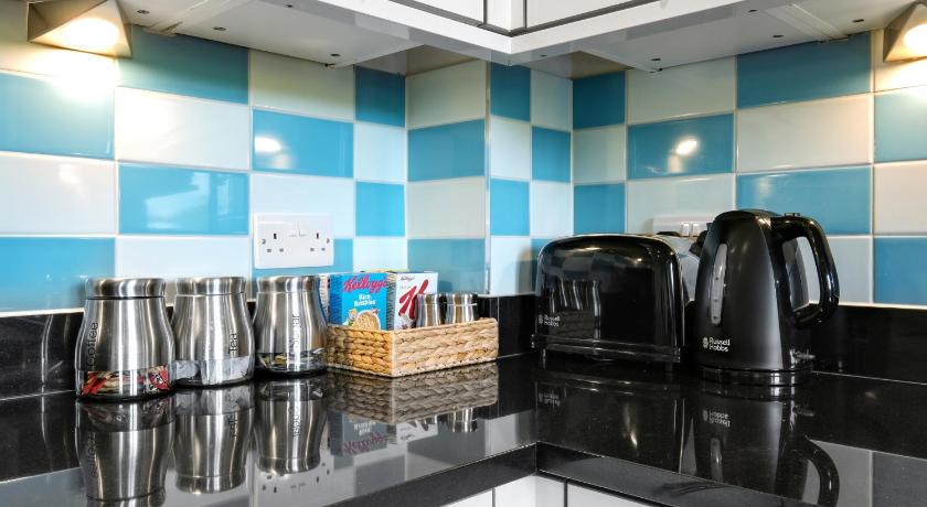 a kitchen with a refrigerator, sink, and microwave, London Heathrow Living Serviced Apartments by Ferndale in London