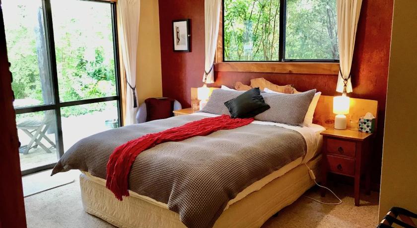 a bedroom with a large bed and a large window, Murchison Lodge in Murchison