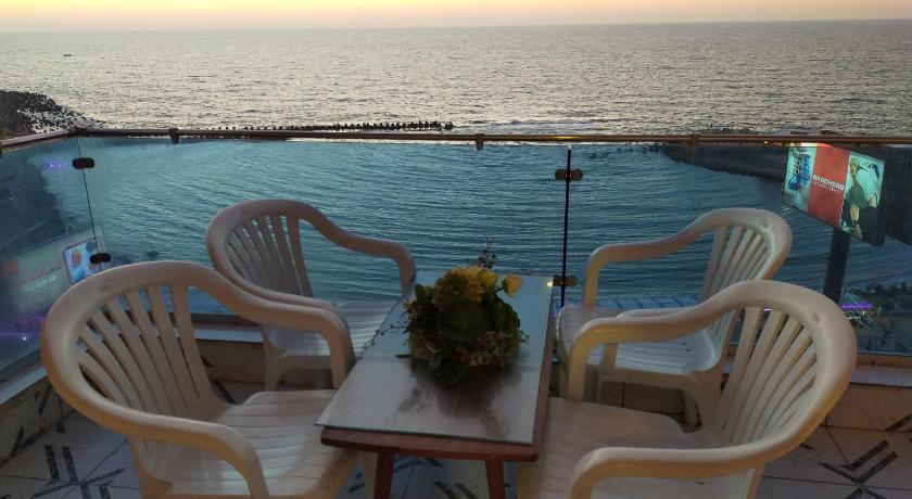 a dining room table with chairs and umbrellas, 26th of July Apartments in Alexandria