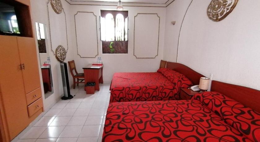a room with a red couch and red pillows, Casa de la Luna in Mexico City