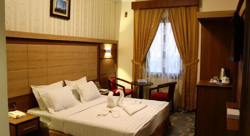 a hotel room with two beds and a table, Diyar Taiba Hotel in Medina