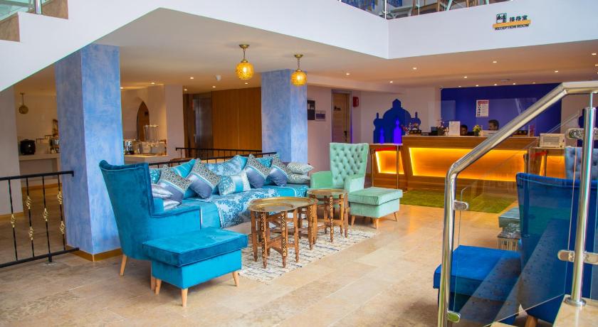 a living room filled with furniture and a staircase, VANCII HOTEL in Chefchaouen